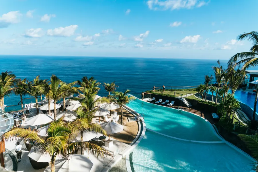 Clifftop resort pool deck overlooking the ocean at sunrise